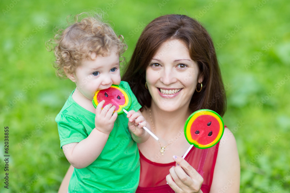 Young beautiful mother and her curly baby eating candys Young beautiful mother and her curly baby eating candys