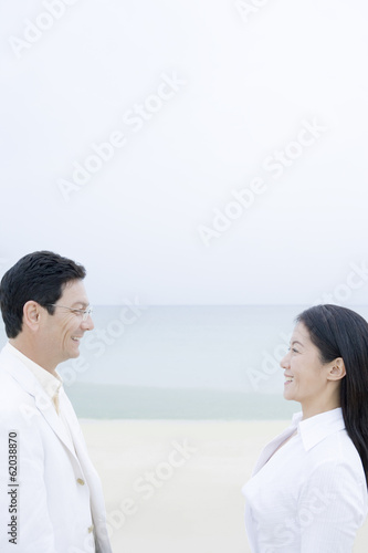 middle aged husband and wife smiling on beach