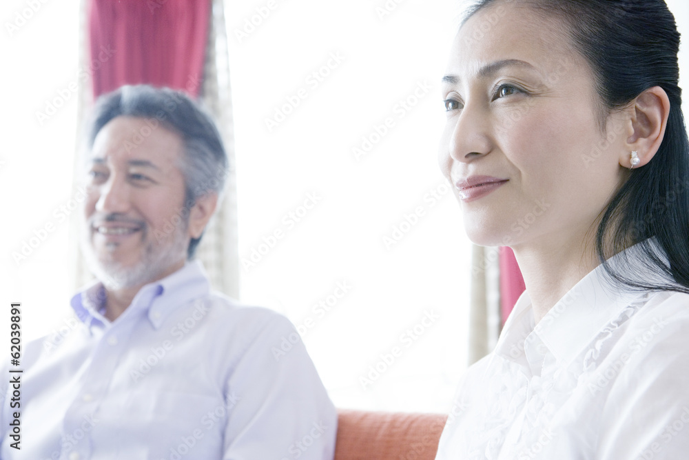 Fototapeta premium husband and wife sitting on sofa side by side