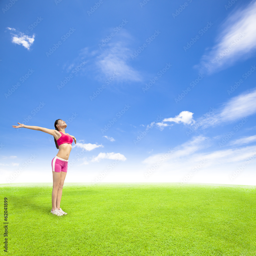 relaxing young woman standing on a meadow with blue sky relaxing young woman standing on a meadow with blue sky