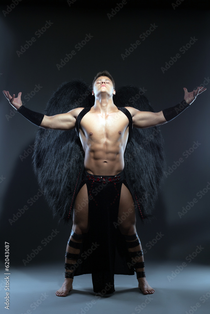 Fototapeta premium Young muscular man posing as fallen angel