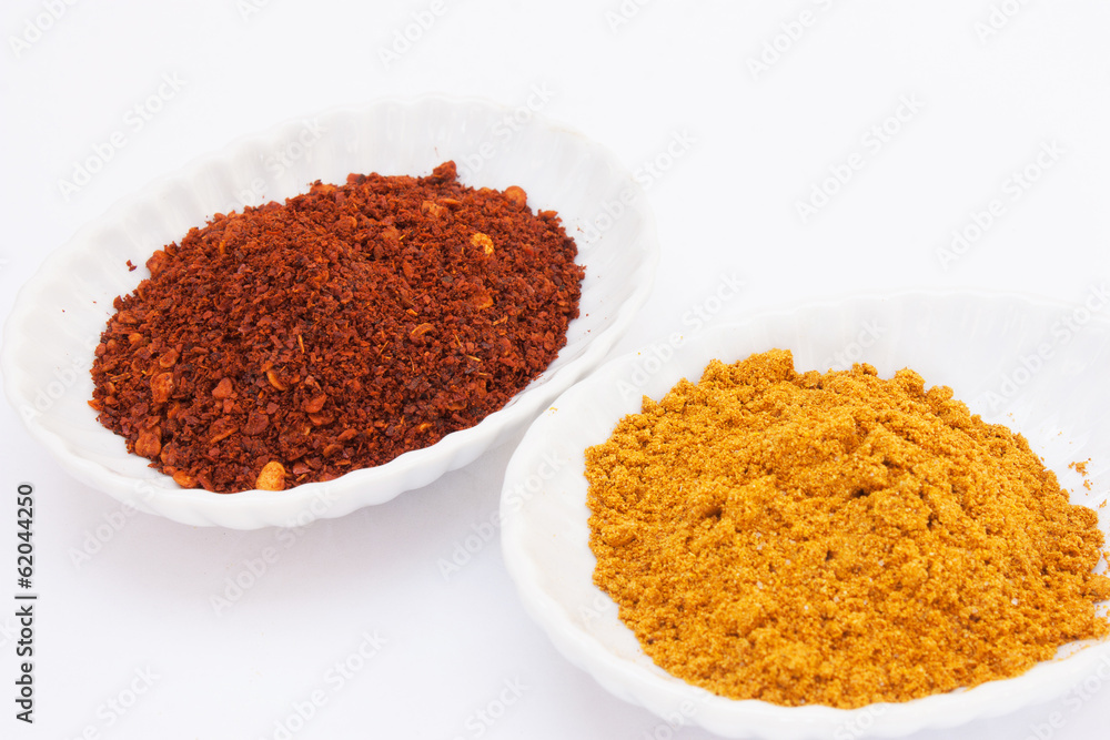 Cayenne pepper and curry powder on white background. Cayenne pepper and curry powder on white background.