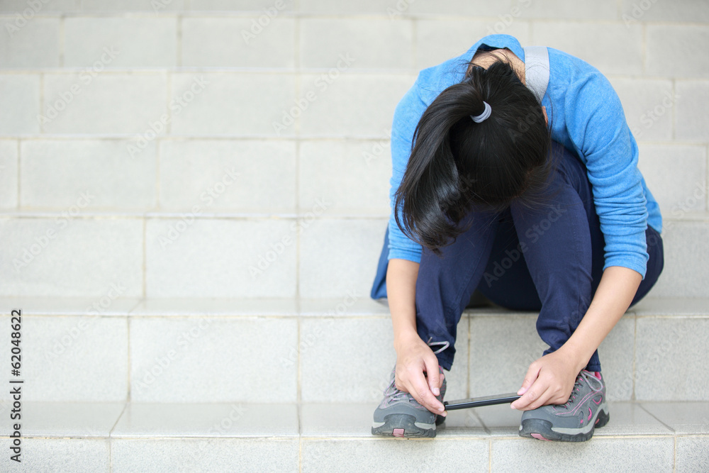 sad woman college student hold cellphone sit on stairs corner