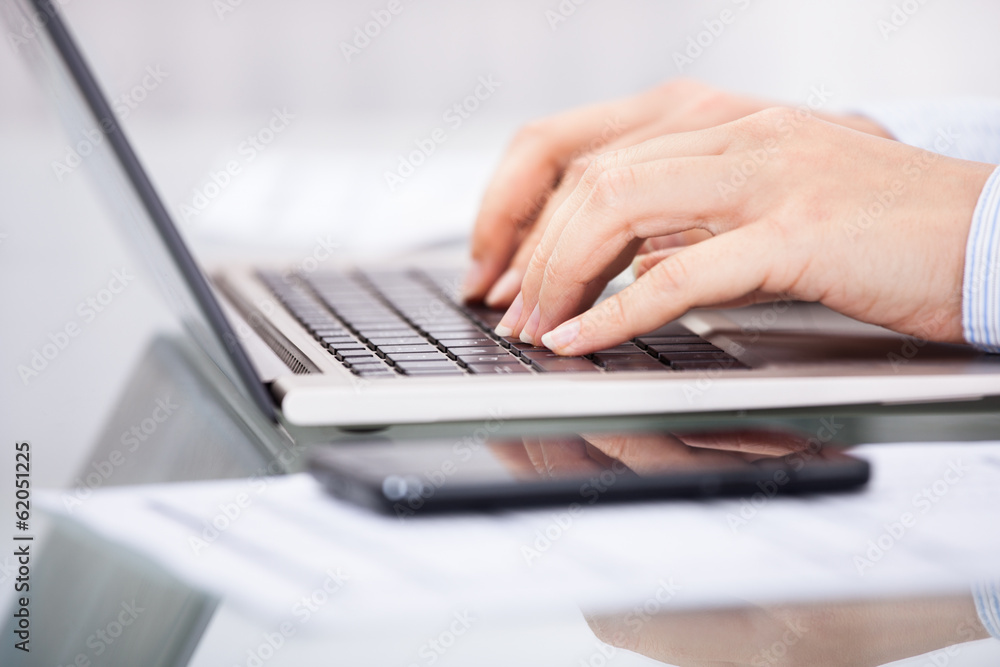 Hand Typing On Laptop With Cellphone Hand Typing On Laptop With Cellphone