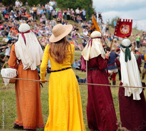 Girls in medieval costumes watching the knightly tournament