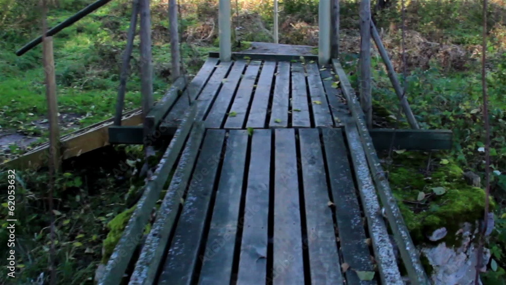Walking on wooden bridge while water flowing under it Walking on wooden bridge while water flowing under it