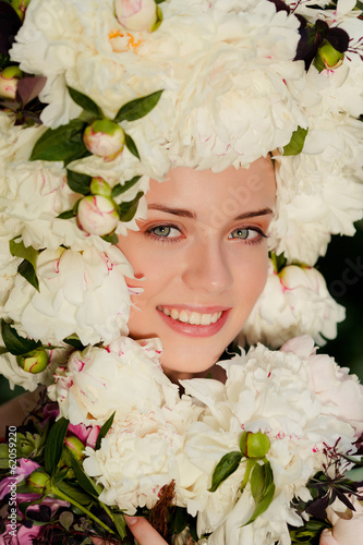 beautiful young girl with a cap of flowers on her head photo