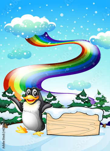 A penguin near the empty signboard and a rainbow in the sky