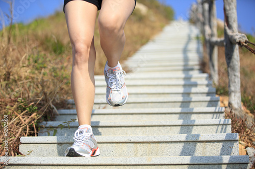sporty woman legs running on mountain stairs