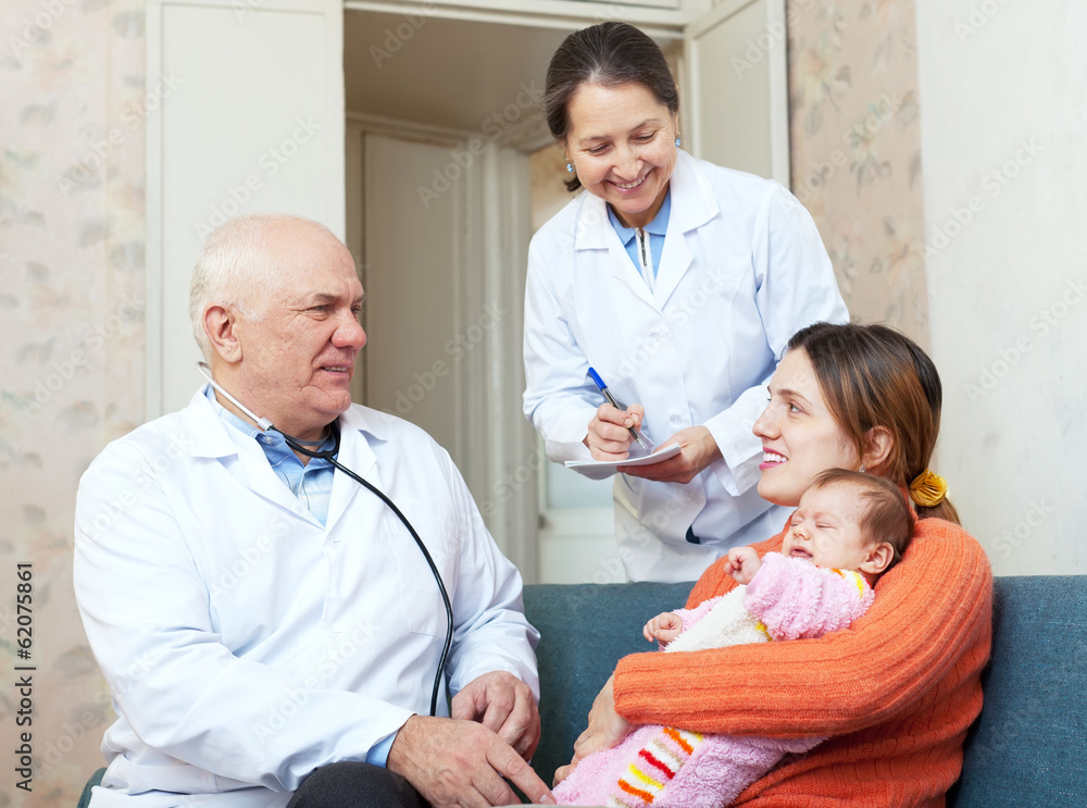 Obraz premium Elderly pediatrician talks to mother of young child