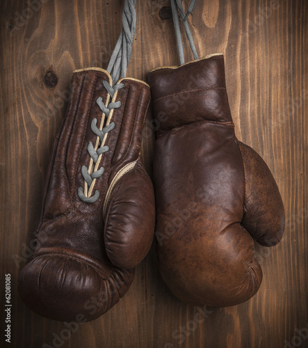 Old boxing gloves with a lace over old wooden wall
