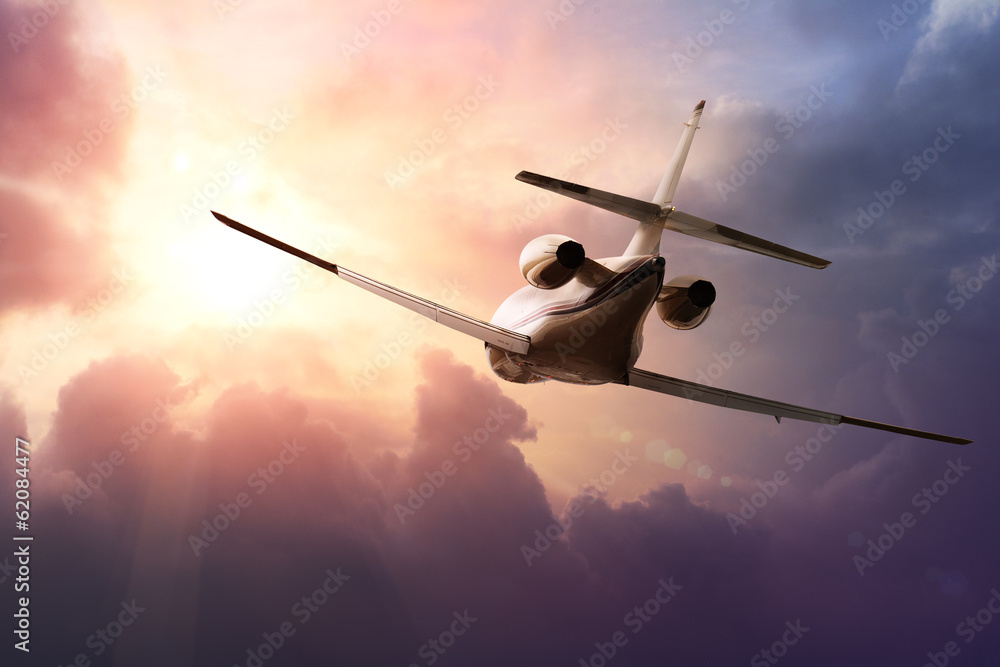 Naklejka premium Prywatny samolot odrzutowy na niebie o zachodzie słońca