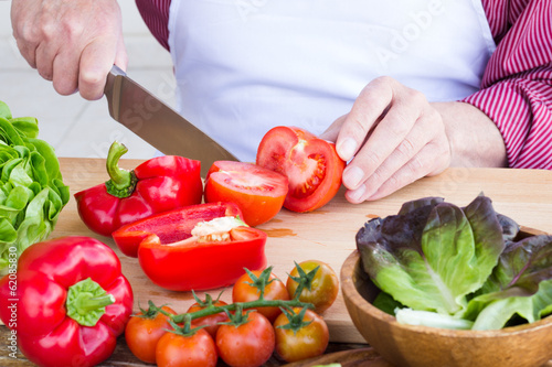Man cutting vegetables for healthy salad