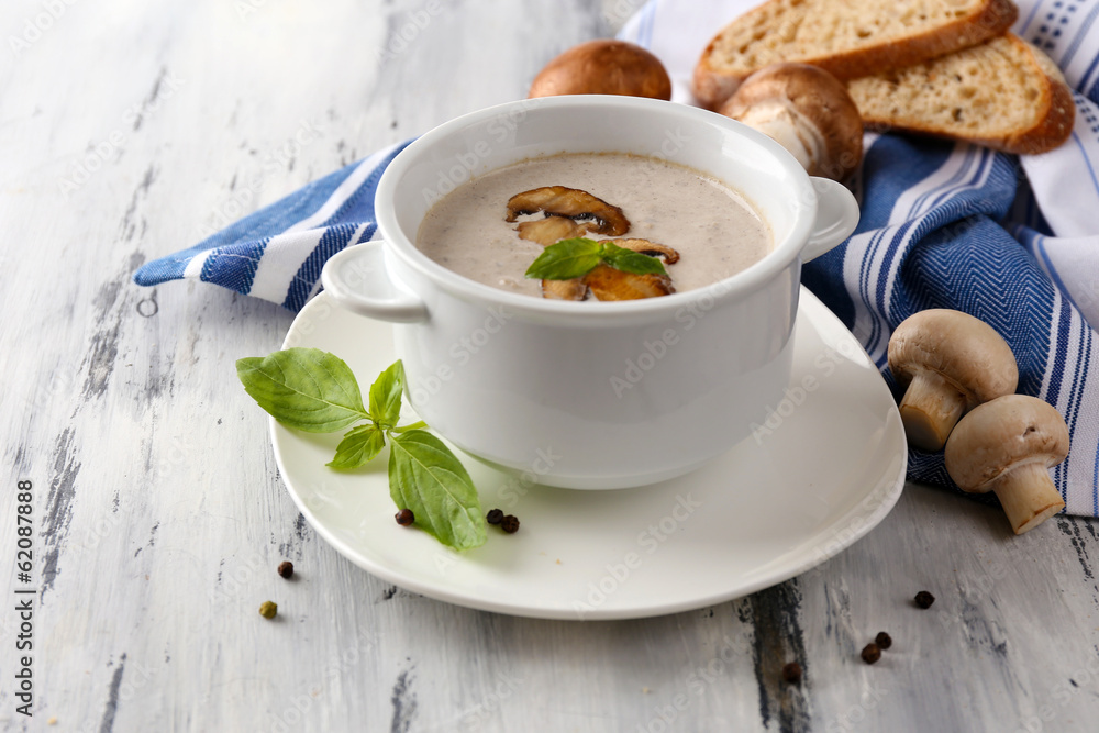 Mushroom soup in white pots, on napkin, on wooden background Mushroom soup in white pots, on napkin, on wooden background