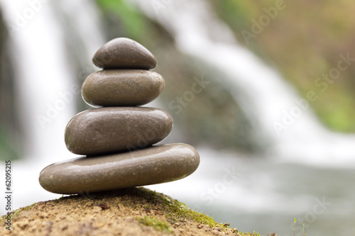 Stacked zen stones and waterfall
