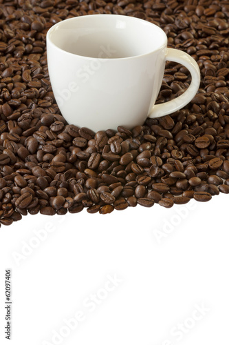 Kaffeetasse steht zwischen vielen Kaffeebohnen