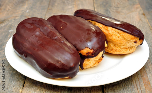 cakes "eclairs" in the plate on wooden table
