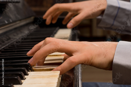 Fotografia Male pianist playing music on an ivory keyboard