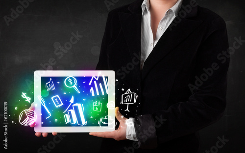 Young person holding tablet with graph and chart symbols