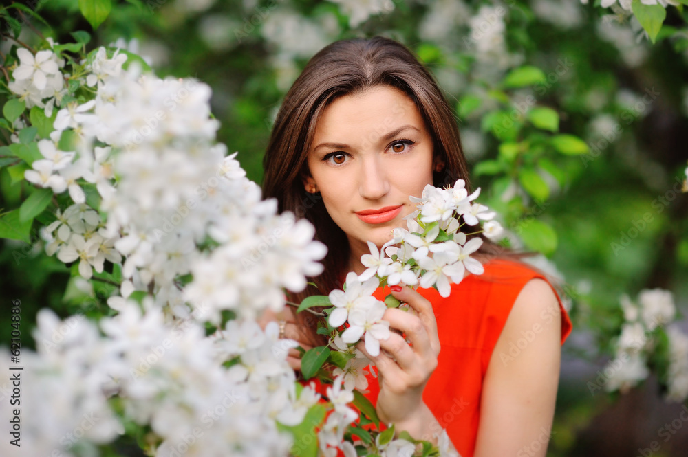 Portrait of brunette girl on a background of flowering trees Portrait of brunette girl on a background of flowering trees