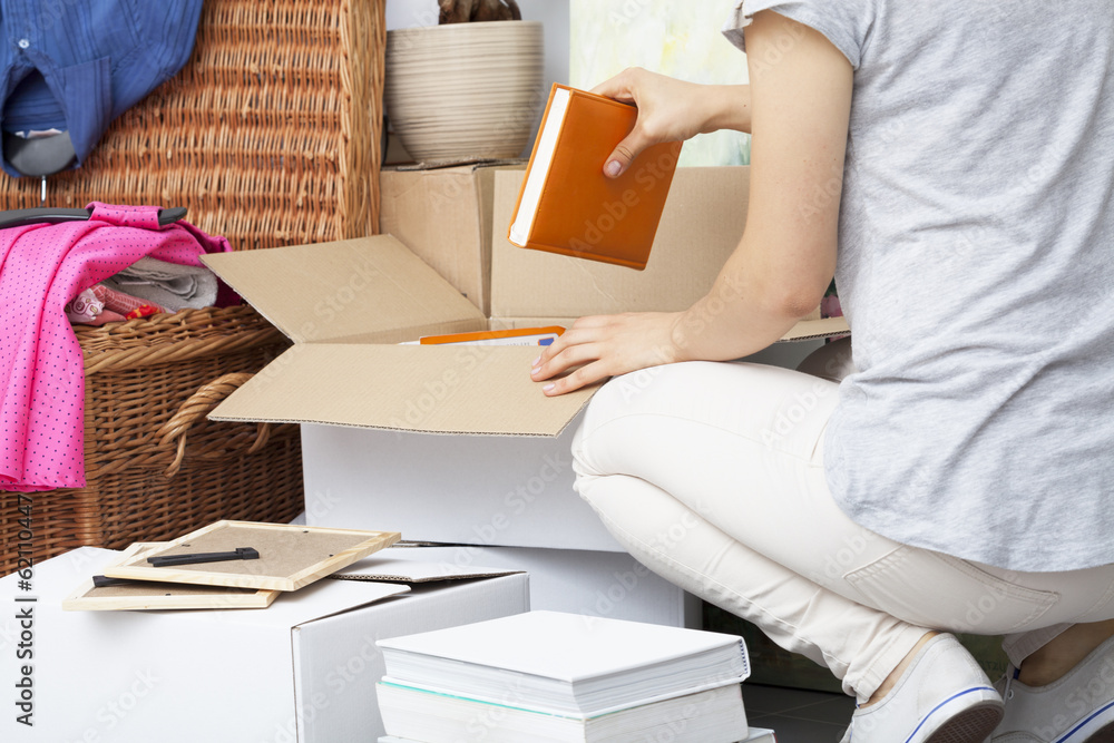 Obraz premium Woman packing house stuff