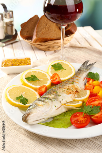 Delicious grilled fish on plate on table close-up