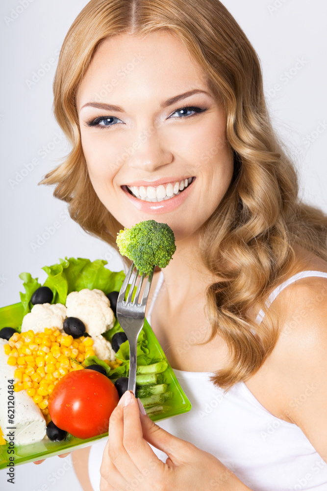 Woman with vegetarian salad, over gray Woman with vegetarian salad, over gray