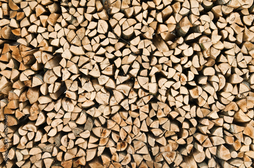 many raw firewood logs stacked texture background