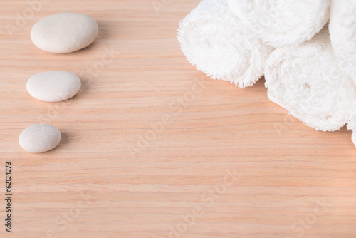 Spa still life with stone and white towel on wood background
