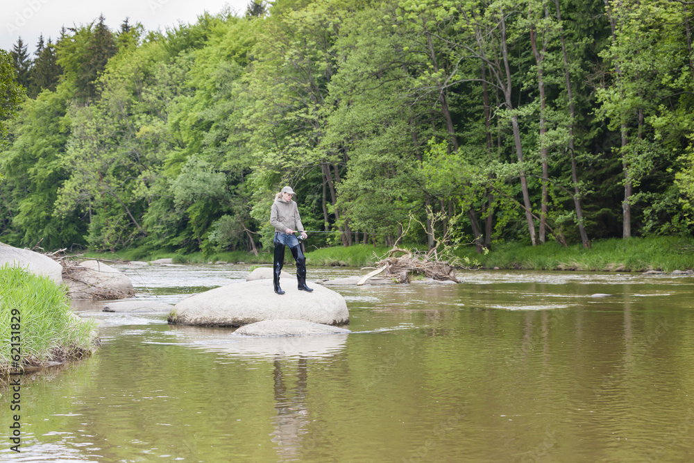 woman fishing in Sazava river, Czech Republic woman fishing in Sazava river, Czech Republic
