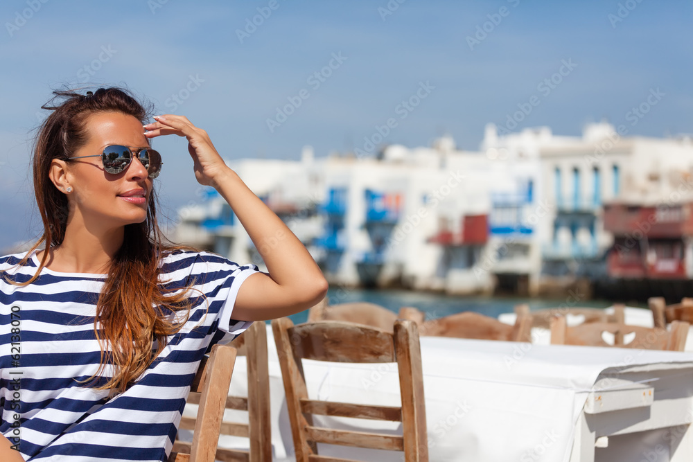 Beautiful woman sitting at a seaside cafe