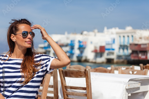 Foto Beautiful woman sitting at a seaside cafe