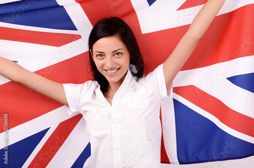 Portrait of a British girl smiling holding up the UK flag.