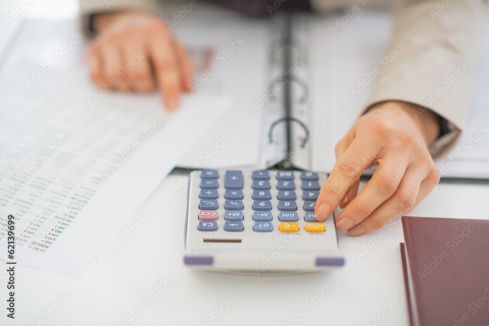 Closeup on business woman using calculator Closeup on business woman using calculator
