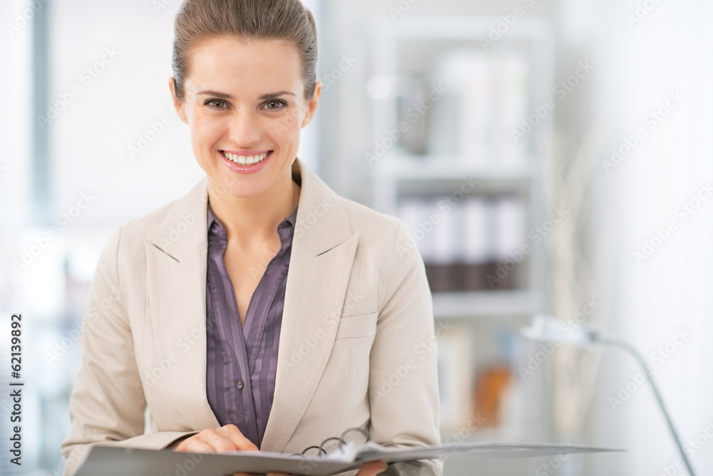 Portrait of smiling business woman with documents in office Portrait of smiling business woman with documents in office