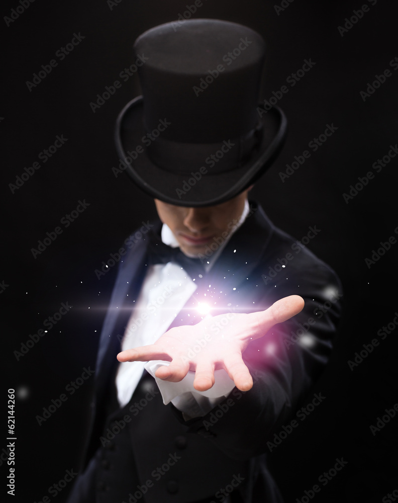 magician holding something on palm of his hand - obrazy, fototapety, plakaty 