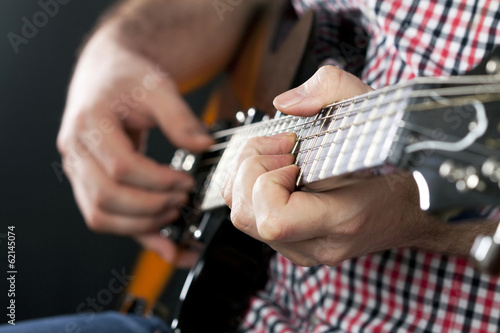 Close up on man playing guitar