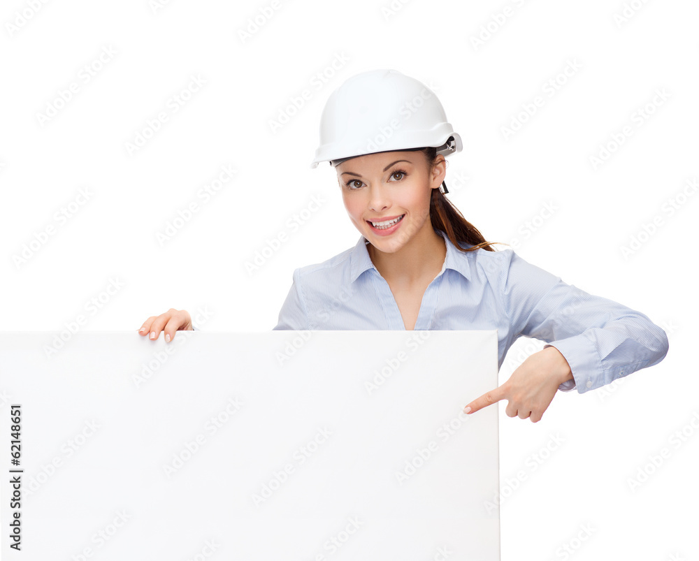 businesswoman in helmet pointing finger to board businesswoman in helmet pointing finger to board