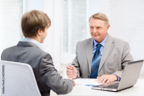 older man and young man having meeting in office