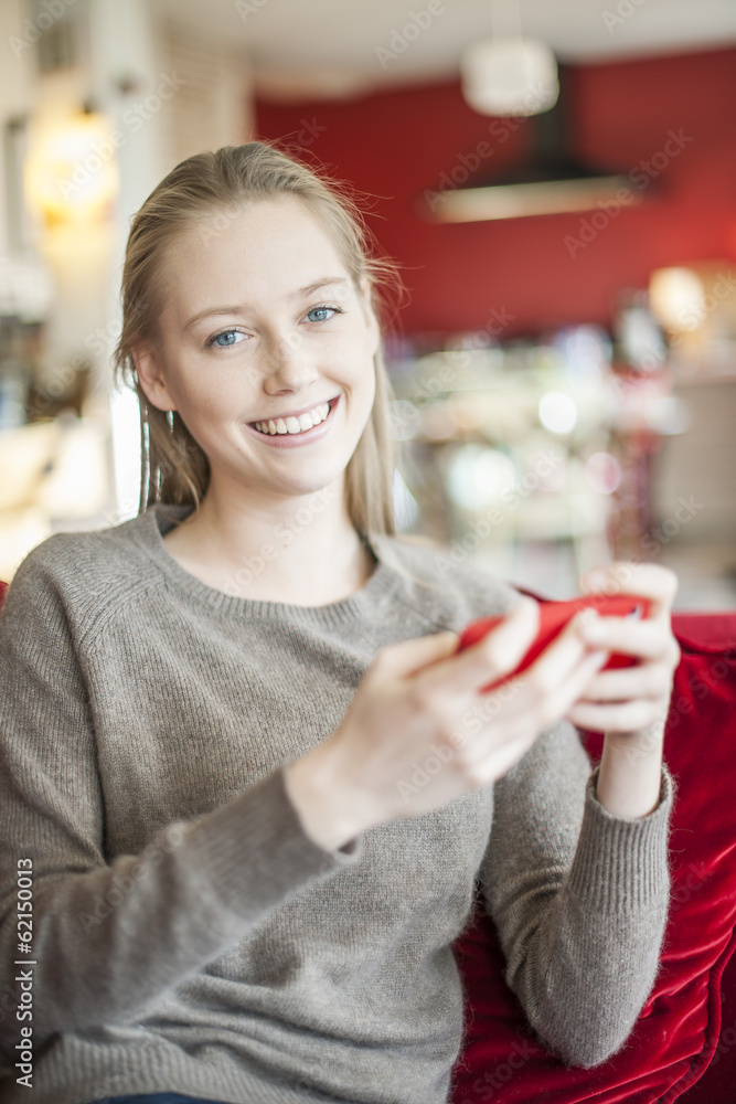 cheerful young woman sending a message on her smartphone sit on cheerful young woman sending a message on her smartphone sit on