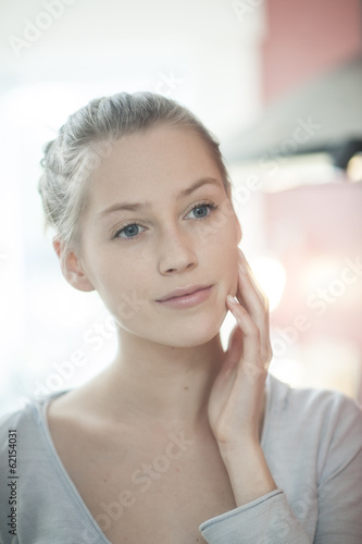 closeup of a beautiful young woman looking herself in a mirror