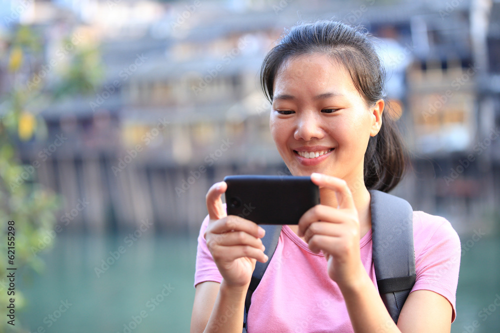 Fototapeta premium woman tourist use smart phone at fenghuang ancient town,china