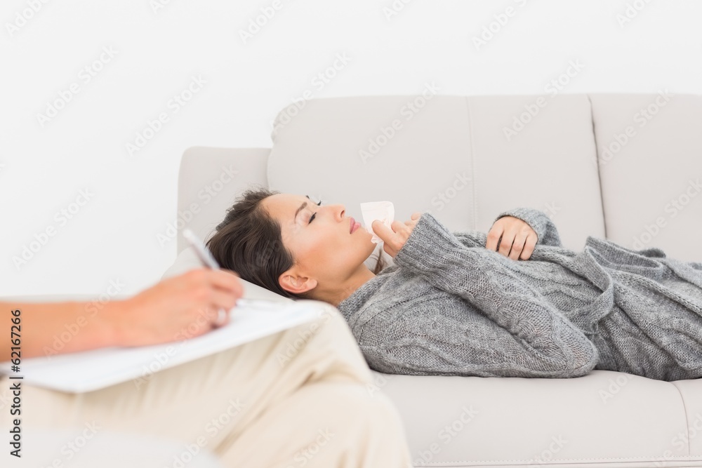 Therapist taking notes on her crying patient on the couch Therapist taking notes on her crying patient on the couch