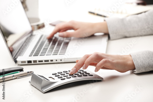 Businesswoman working on laptop and calculating data