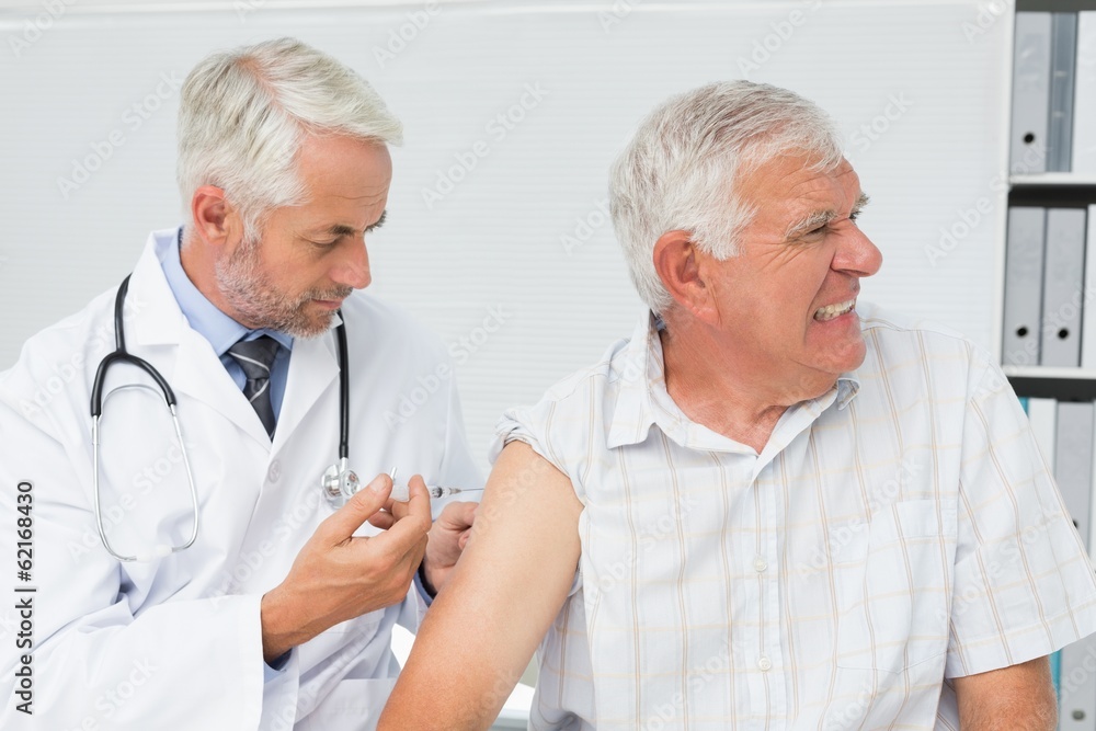 Doctor injecting senior male patient