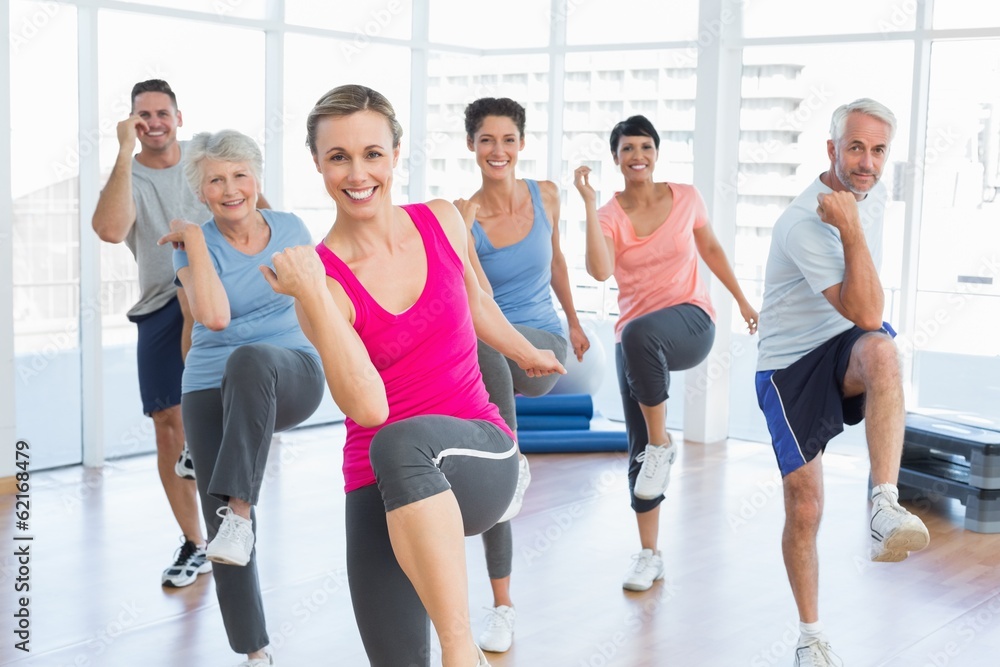 Smiling people doing power fitness exercise at yoga class Smiling people doing power fitness exercise at yoga class