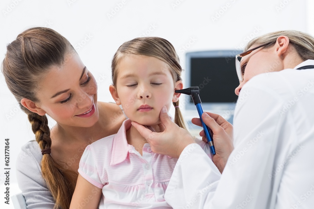 Girl being examined by doctor with otoscope Girl being examined by doctor with otoscope
