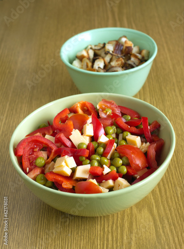 Vegetable salad and croutons with onion in bowls closeup