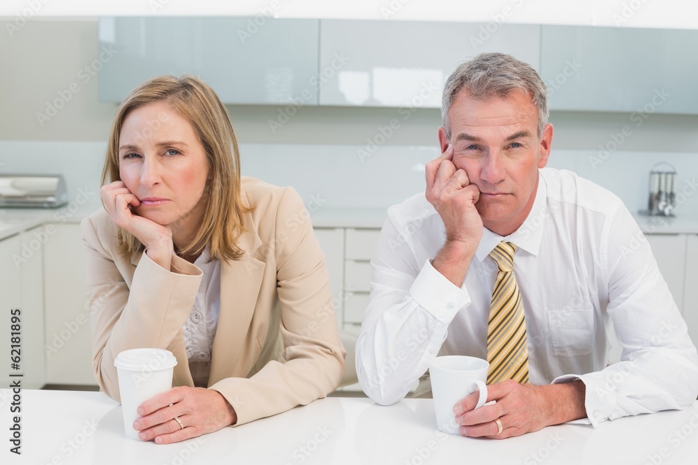 Business couple not talking after an argument in kitchen Business couple not talking after an argument in kitchen
