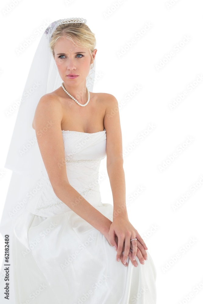 Thoughtful bride sitting against white background Thoughtful bride sitting against white background